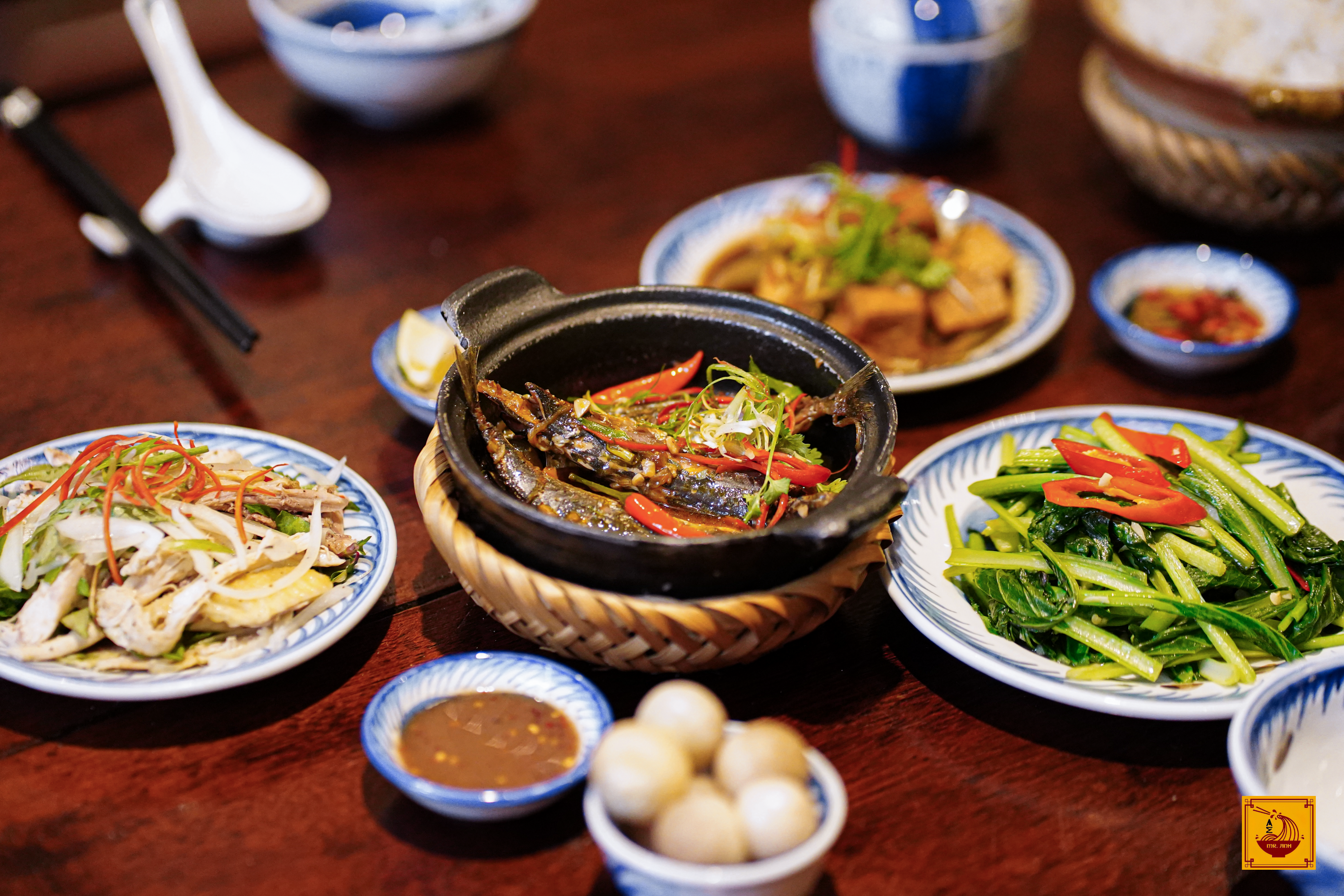 Mâm cơm Việt với cá kho tộ, rau muống xào và gỏi gà